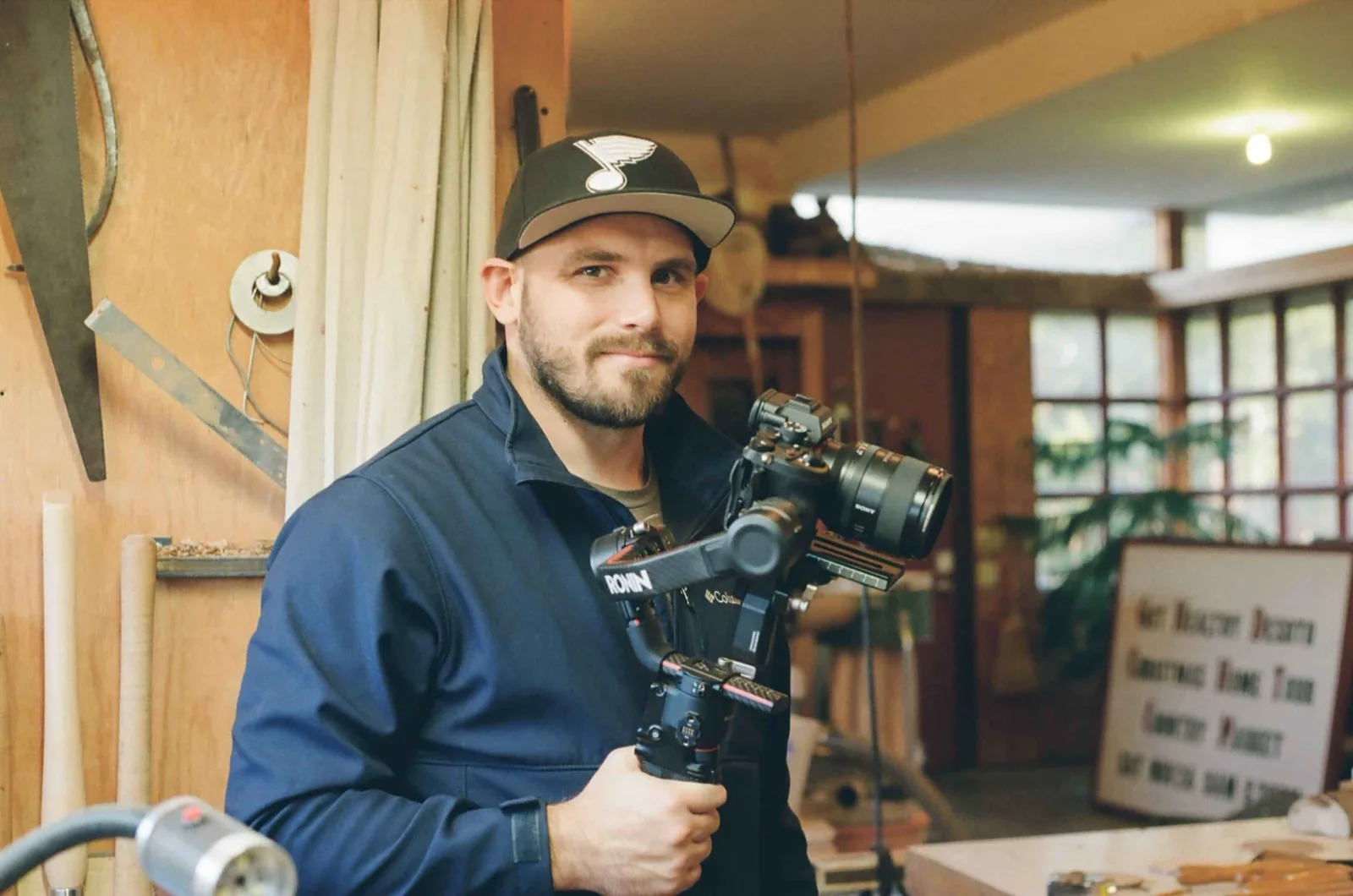Corporate video production in O'Fallon, MO: Mark Mattei holding a gimbal-mounted mirrorless camera inside a woodworking shop
