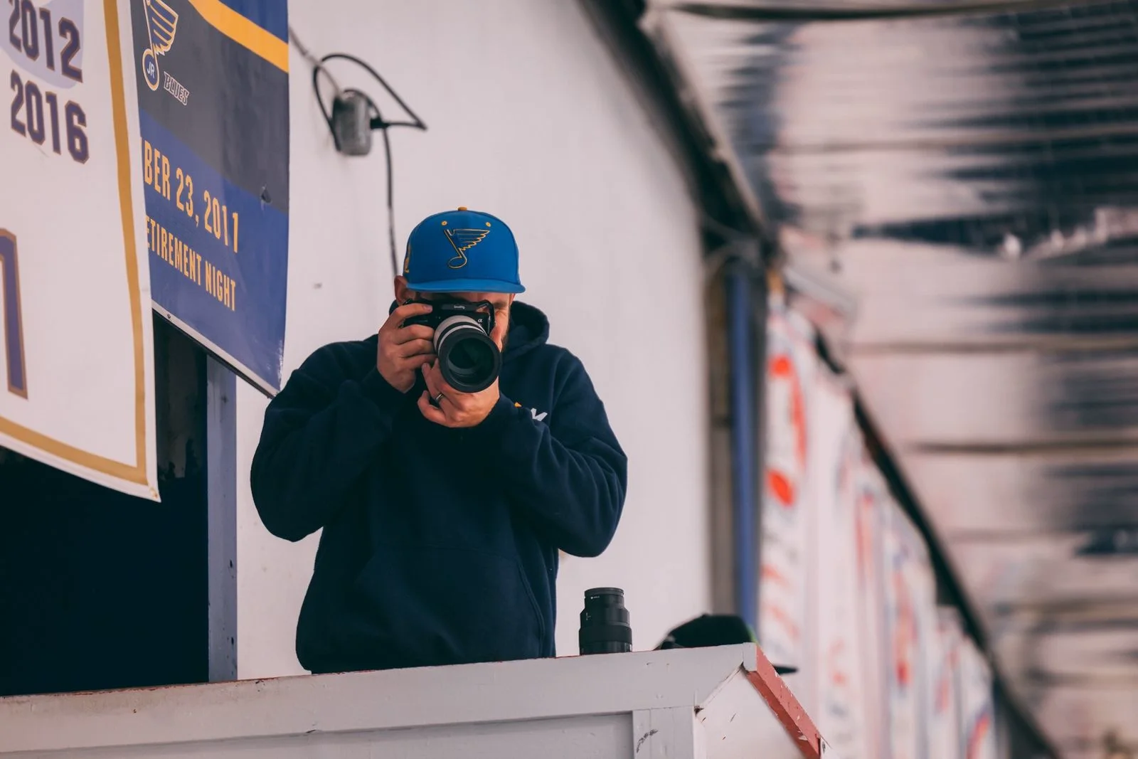 O'Fallon MO video production: Mark Mattei of MEM Films in a St. Louis Blues cap photographing from the Enterprise Center press box