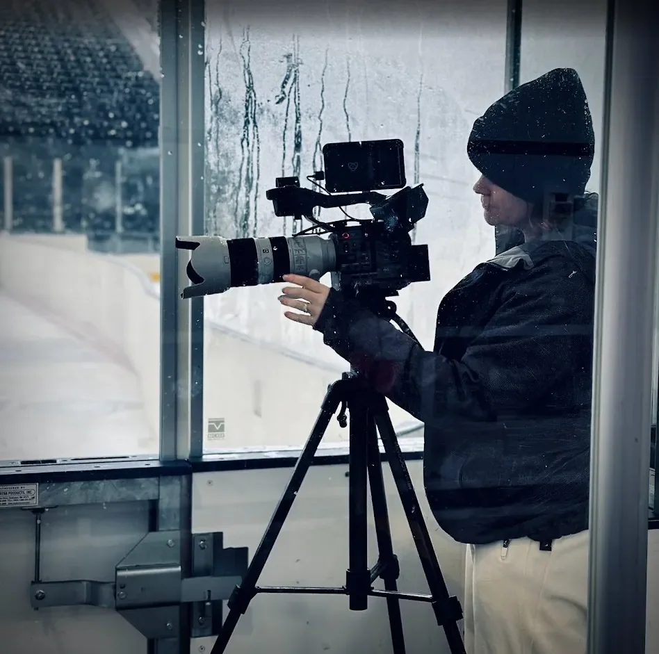 Video production in St. Charles, MO: Emma Mattei of MEM Films filming an ice rink from behind the glass with a cinema camera on a tripod