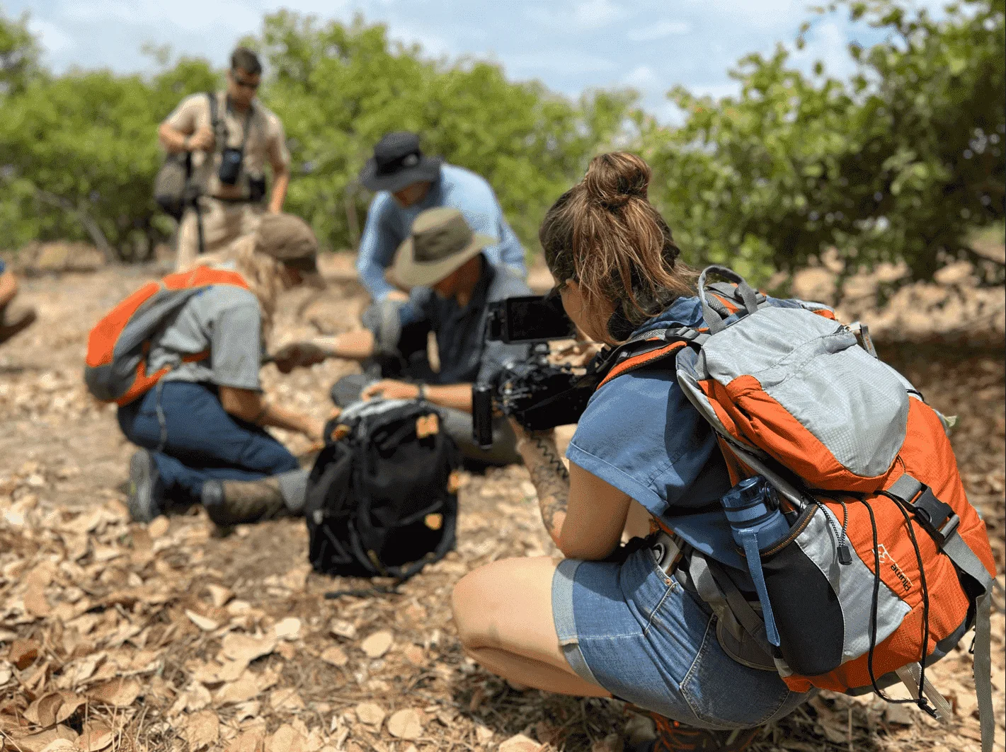 Video production in Wentzville, MO: Emma Mattei of MEM Films filming a field crew in a wooded area with a cinema camera