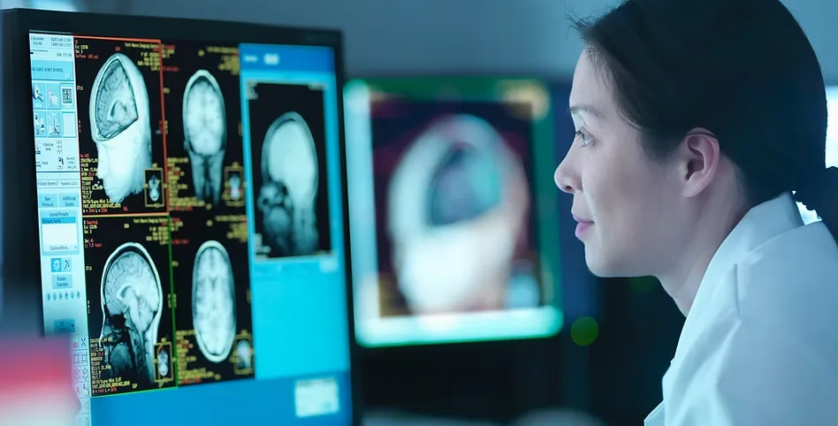 Medical video production for Creve Coeur, MO healthcare providers: clinician reviewing brain scans on a bank of monitors