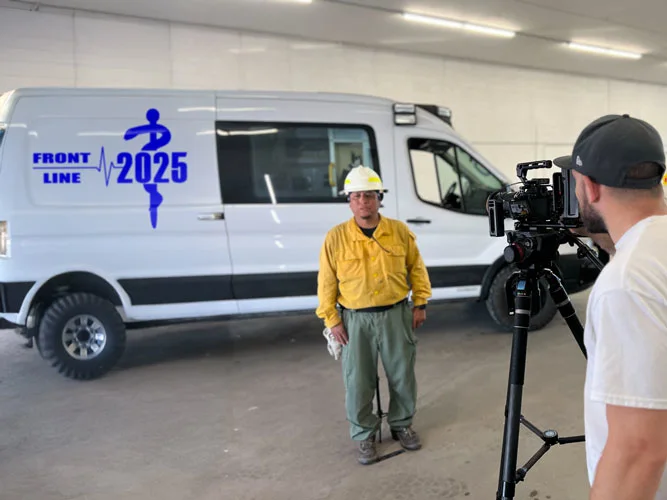 Healthcare video production for Creve Coeur, MO providers: MEM Films filming a Front Line team member in a hard hat beside a branded van
