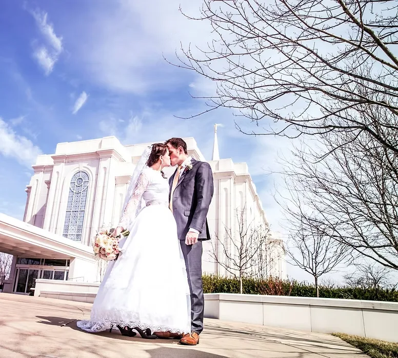 O'Fallon MO wedding videographers Mark and Emma of MEM Films kissing outside the St. Louis Missouri Temple on their own wedding day