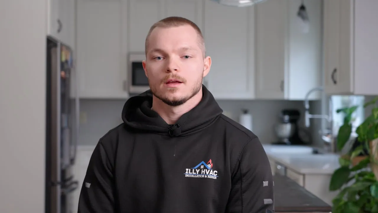 Illy HVAC spring cleaning explainer: technician in a black Illy HVAC hoodie speaking in a kitchen